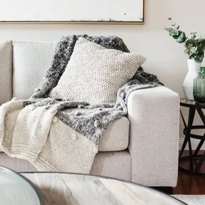 indoor scene showing couch, cushions and side table